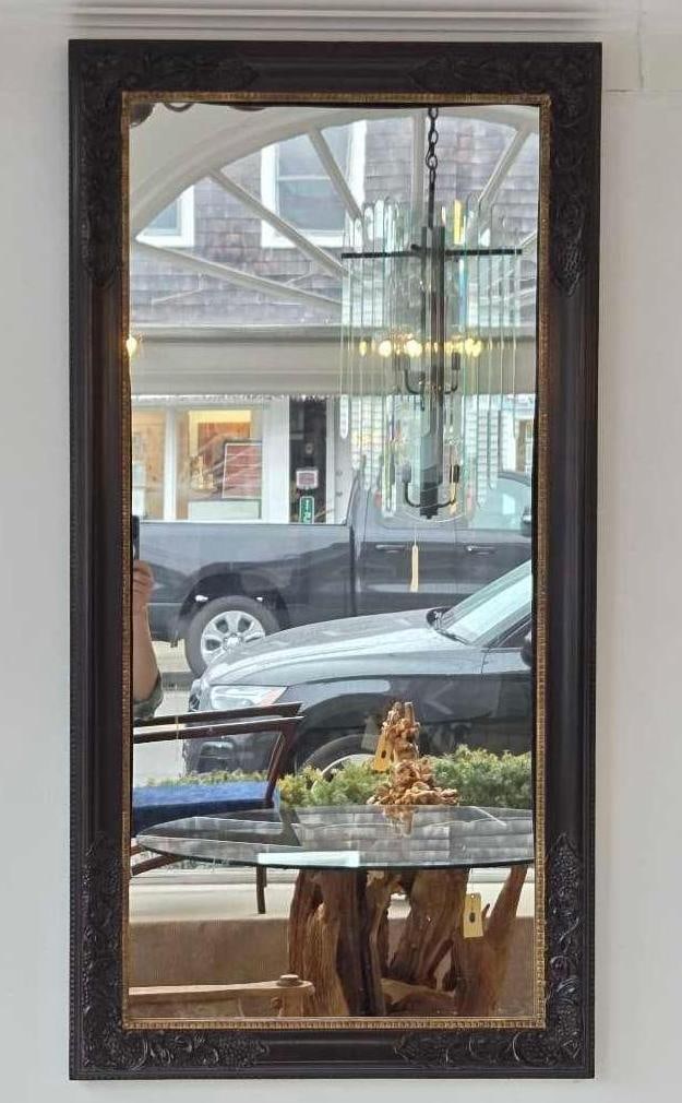 CARVED MAHOGANY FINISH LARGE WALL MIRROR: Traditional vertical rectangular mirror with a formal deep-relief carved frame Approximate Dimensions: 48” x 24” Artist or Maker: Unknown Provenance: From a New York Collector Notes: Altho