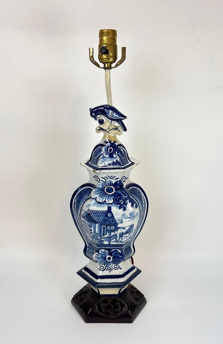 LARGE ANTIQUE BLUE AND WHITE DELFT URN TABLE LAMP: **High-shouldered tin-glazed lidded, baluster-shaped vase featuring hand-painted chinoiserie decorations in cobalt blue underglaze mounted as a table lamp with a decorative finial set on a carved wood