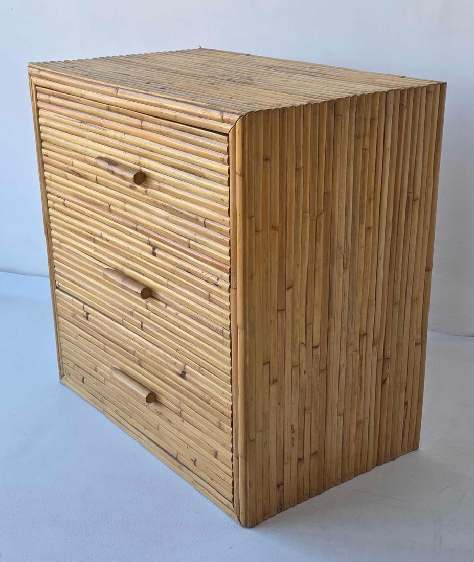 VINTAGE COASTAL MODERN PENCIL REED RATTAN THREE-DRAWER COMMODE CHEST: *Mid-century modern three-tier storage chest constructed with vertical pencil reed bamboo wraps and matching cylindrical wood pulls. Approximate Dimensions: 30.5"h x 30.75"w x 19"d Artist or Maker: Un