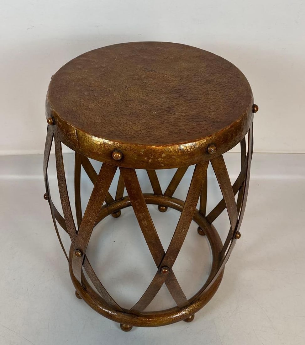 JOHN-RICHARD HAMMERED BRASS DRUM SIDE TABLE: *Vintage-style drum table with a hammered circular brass top and an openwork lattice base accented by decorative stud hardware. Approximate Dimensions: 28”h x 22.5”w x 22.5”d Artis