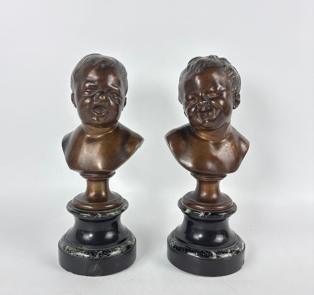 PAIR OF 19TH CENTURY FRENCH INFANT BRONZE BUSTS ON MARBLE BASES: *Pair of patinated bronze sculptures of crying and laughing infant heads mounted on turned marble and black stone pedestals Approximate Dimensions: 9.5"h Artist or Maker: Unknown Provenance: Fro