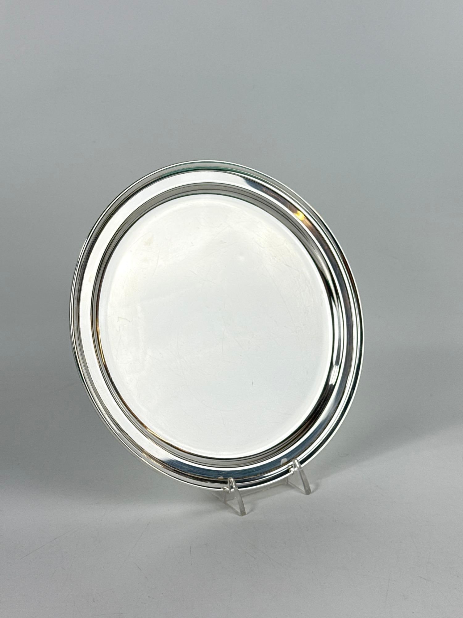 TIFFANY & CO. ROUND TRAY IN STERLING SILVER: *A sterling silver circular tray with minimalist stepped rim. Comes with the Tiffany blue box & pouch. Approximate Dimensions: 8”Dia Approximate Weight: 9.5 ozt Maker: Tiffany & Co. P