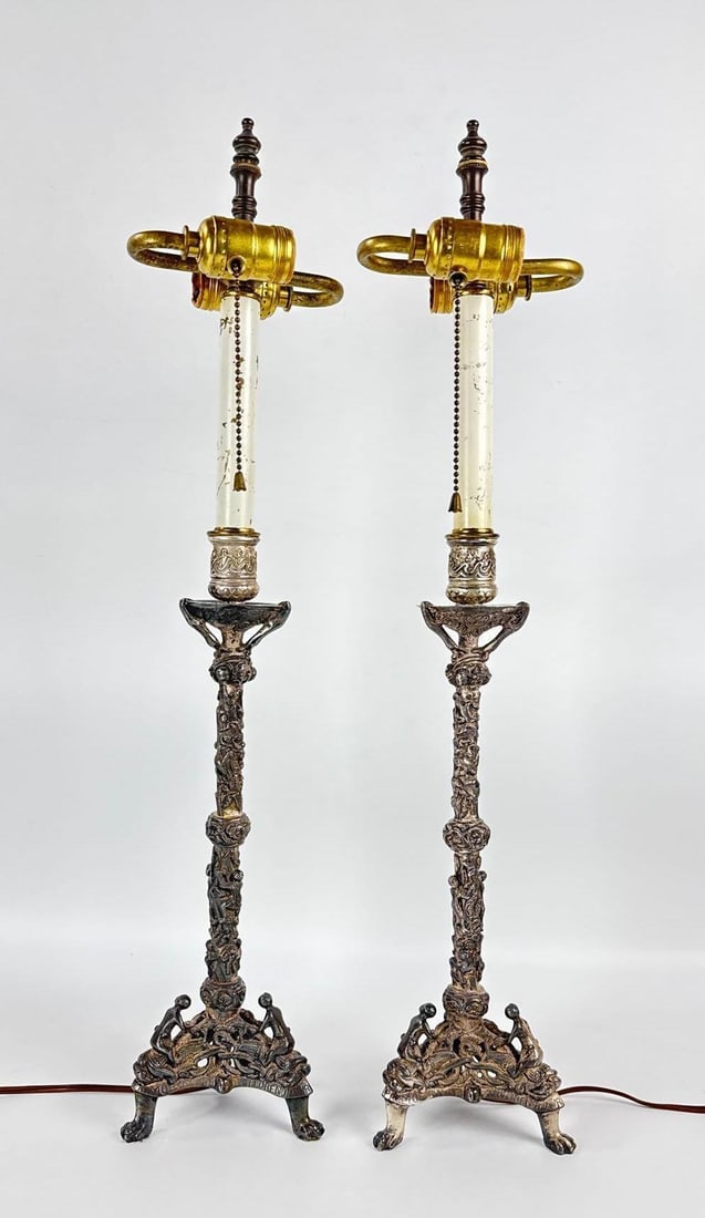 EXCEPTIONAL PAIR OF ANTIQUE FRENCH NEOCLASSICAL SILVERED BRONZE CHERUB COLUMN LAMPS: Matched set of stately table lamps featuring silver-toned metal winged cherub tripod bases supporting tall white fluted columns and classic candlestick-style sockets. Approximate Dimensions: 26"h