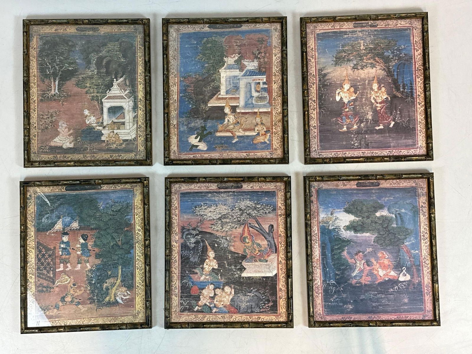 SET OF 6 TGROUP OF SIX THAI BUDDHIST JATAKA PRINTS IN VINTAGE FAUX BAMBOO FRAMES: Collection of six prints on paper depicting scenes from the life of Buddha in traditional Rattanakosin style professionally housed in faux-bamboo gilt frames. Approximate Dimensions: