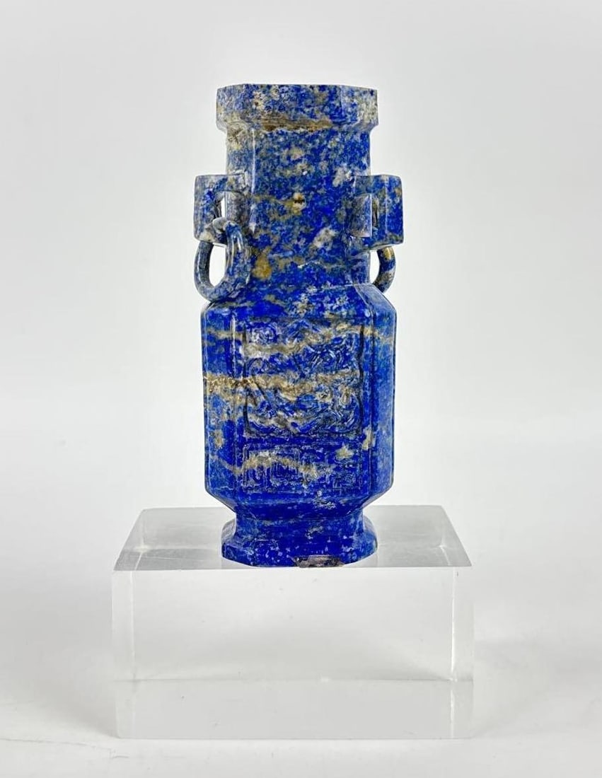 CARVED LAPIS LAZULI VESSEL: An antique, hand-carved, deep blue lapis lazuli urn with a cloud-motif relief on the body and foo dog lid. Approximate Dimensions: largest 5”H x 2.75”W x 2”D Artist or Maker: Unkno