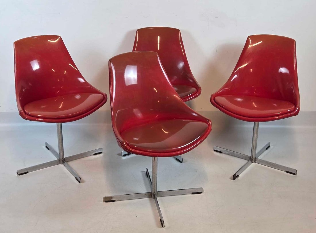 SET OF FOUR MID CENTURY MODERN RED ORANGE VINYL UPHOLSTERED SWIVEL CHAIRS: A set of four red vinyl shell chairs mounted on chrome-plated swivel bases. Approximate Dimensions: 30.75"H x 21"W x 21"D Artist or Maker: Unknown Provenance: From a New York Collector