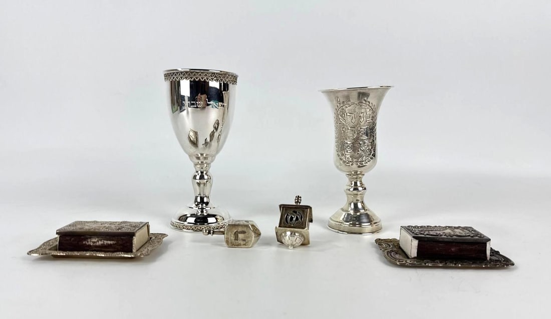 ESTATE JUDAICA LOT INCLUDING STERLING SILVER KIDDUSH CUPS AND DREIDELS: Collection of religious ceremonial items comprising two silver wine goblets with Hebrew inscriptions, matched filigree matchbox covers, and two decorative Hanukkah dreidels. Approximate Dimensions: