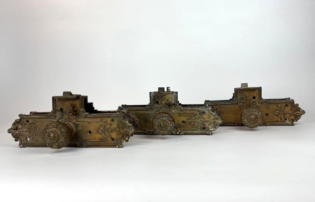 GROUP OF 3 ANTIQUE BRONZE MORTISE DOOR KNOBS: *Victorian-era decorative cast brass mortise lock assemblies with matching embossed knobs and intricate floral backplates Approximate Dimensions: 12.25”h x 4.5”w x 7”d Artist