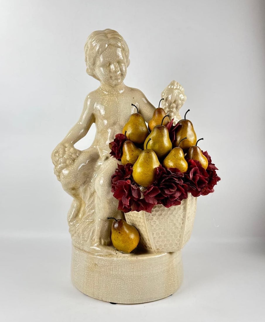 ITALIAN STYLE CERAMIC STATUE BOY WITH GRAPES AND FAUX FRUIT: Large scale crackle glaze earthenware figure of a seated youth with harvest motif and decorative pear arrangement. Approximate Dimensions: 26.35”h x 17”w x 13”d Artist or