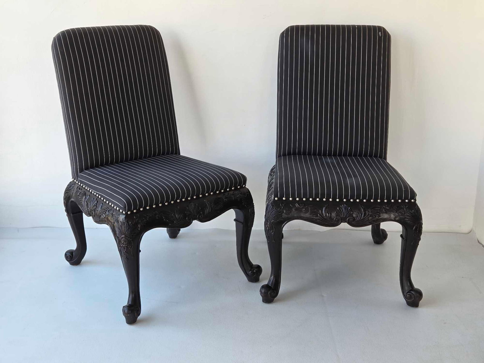 PAIR OF RALPH LAUREN HOME BEL AIR ROCOCO CARVED BLACK LACQUER SIDE CHAIRS (2 of 3): *Pair of ebonized mahogany dining chairs with elaborate shell and acanthus leaf-carved aprons on cabriole legs upholstered in pinstripe fabric with silver-tone nailhead trim. Approximate Dimensions: 3