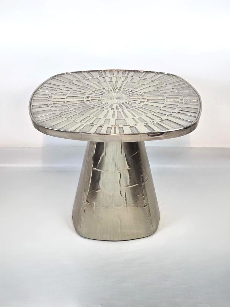 JONATHAN ADLER TALITHA NICKEL-PLATED SILVER LEAF SIDE TABLE: Square pedestal accent table featuring a hand-stamped nickel-plated metal sunburst-patterned top over a wooden core. Approximate Dimensions:23"h x 26.5"w x 26.5"d Maker: Jonathan Adler