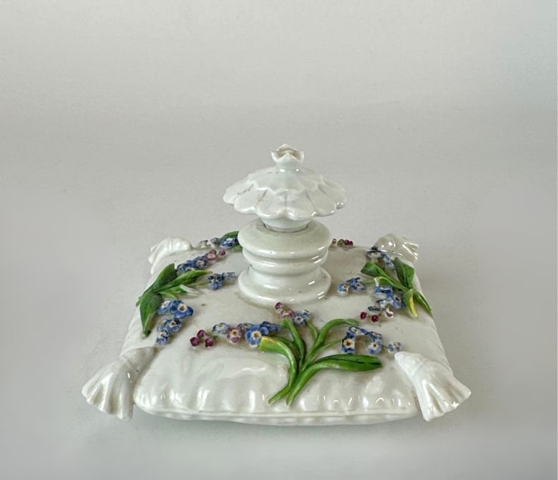 ANTIQUE MEISSEN PORCELAIN "CUSHION" SCENT BOTTLE: A rare and highly decorative 19th-century hard-paste porcelain scent bottle or flacon, whimsically modeled in the form of a plump, tufted silken cushion. The "pillow" features a crisp white gl