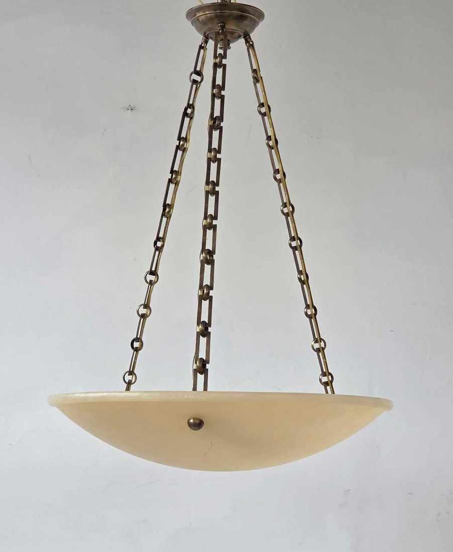 ALABASTER BOWL PENDANT LIGHT FIXTURE: A smooth alabaster stone pendant light suspended by triple bronze-finish chains. Approximate Dimensions:30"H x 23"Dia Artist or Maker: Unknown Provenance: From a New York Collector Notes: