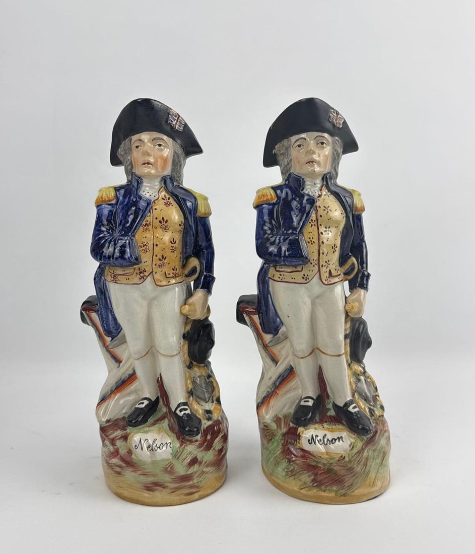 TWO HAND PAINTED CERAMIC ENGLISH DRINKING NELSONS: Set of two hand-painted vintage ceramic standing figures depicting Admiral Lord Nelson in traditional 19th-century naval regalia. Approximate Dimensions: 11.5”h x 4.5”w x 5.5”h