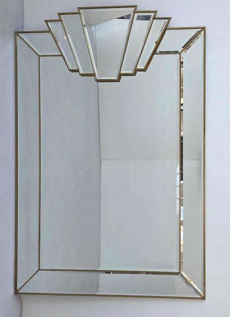 HOLLYWOOD REGENCY BRASS AND BEVELED MIRROR FRAMED MIRROR: Large-scale wall mirror featuring a segmented beveled mirror frame bordered by polished brass trim with ornamental corner medallions.= Approximate Dimensions: 47.5"h x 32"w Artist or Maker