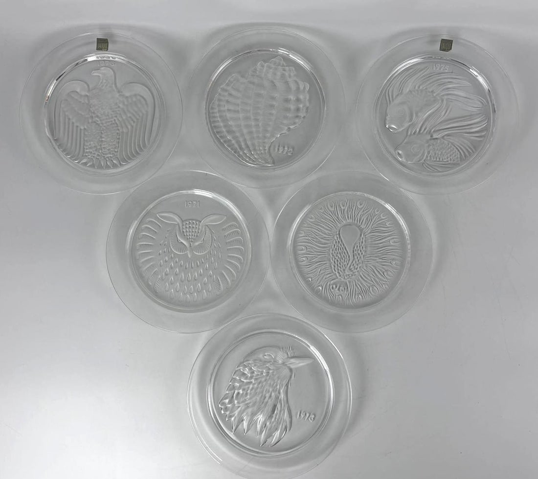 GROUP OF SIX LALIQUE FRANCE CRYSTAL ANNUAL COLLECTOR PLATES: **Set of six frosted and clear lead crystal decorative plates with varying relief-molded nature motifs from the 1970s including: 1973 (eagle head), 1972 (seashell), 1975 ("Duo de Poisson" or &