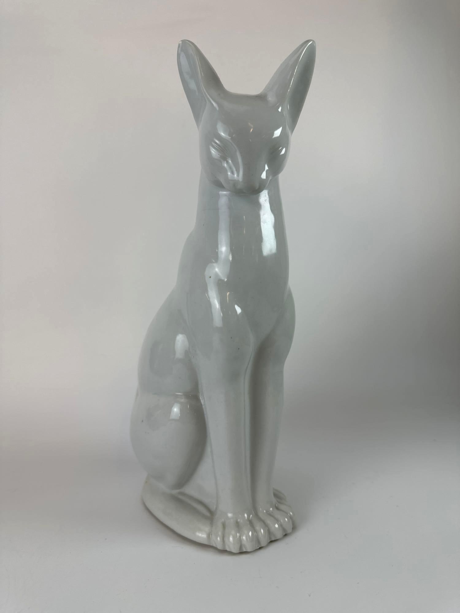SIGNED JAPANESE ART PORCELAIN MODEL OF A SEATED CAT: *A fine mid-century Japanese white-glazed porcelain sculpture of a stylized feline, featuring an elegant elongated silhouette and hand-impressed artist seal on the underside (attributed to Heisui). Ap