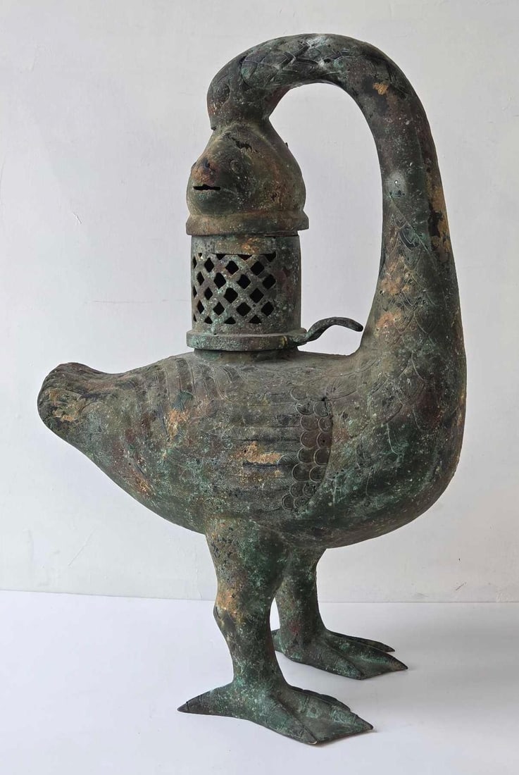 LARGE CHINESE BRONZE ARCHAISTIC GOOSE AND FISH FIGURAL BURNER/ OIL LAMP: Ancient-style ritual vessel in the form of a standing waterfowl holding a fish in its beak with a pierced lattice cylinder. Approximate Dimensions: 32"h x 21"w x 12.5"d Artist or Maker: Un