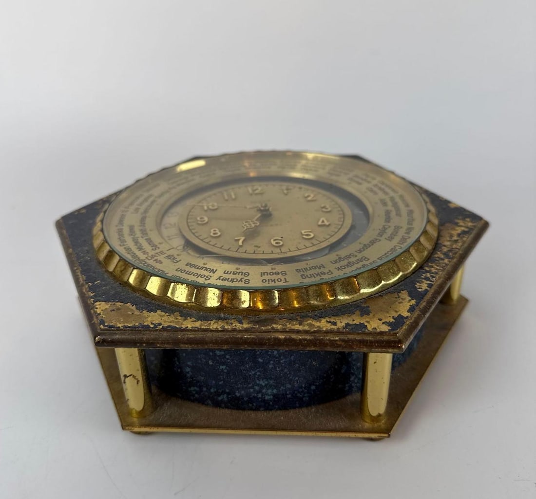 LUXOR SWISS MADE HEXAGONAL WORLD TIME BRASS DESK CLOCK: Vintage Swiss-made world time desk timepiece in a hexagonal brass case with a blue enameled base and rotating outer bezel listed with major global cities. Approx. dimensions: 8" DIA X 2" H Art