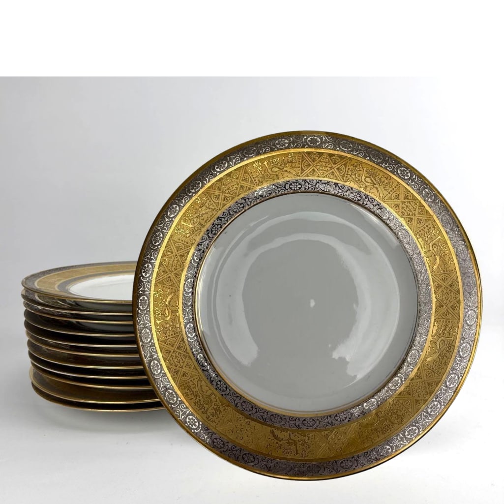 SET OF 12 HUTSCHENREUTHER SELB BAVARIA GOLD ENCRUSTED SERVICE PLATES: Set of twelve German porcelain service plates with a wide ornate heavy gold encrusted filigree border on a white ground. Some wear to all gilding Approximate Dimensions: 11” dia Artist or Maker: