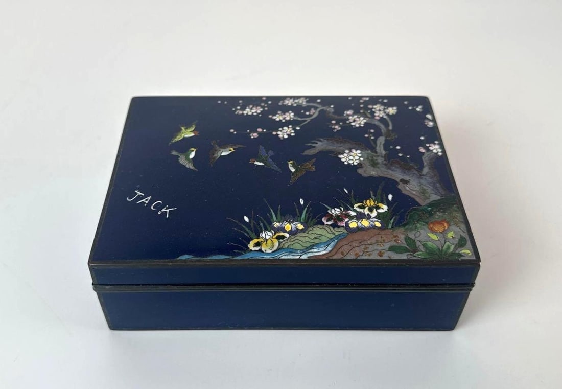ANTIQUE JAPANESE CLOISONNÉ ENAMEL KORO / BOX: A fine Japanese cloisonné enamel lidded box, featuring an intricate design of birds and cherry blossoms against a deep midnight blue ground. Approximate Dimensions: 1.75”H x 4”L x 5.5&rdq