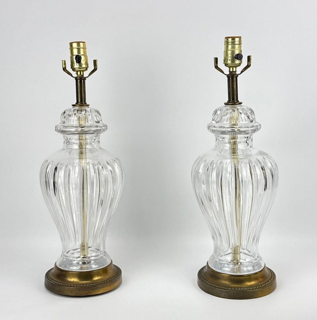 PAIR OF FLUTED CRYSTAL URN-FORM TABLE LAMPS: A pair of table lamps featuring heavy lead crystal bodies with deep vertical miter cuts (fluting). Approximate Dimensions: 19”h x 6.5”dia Artist or Maker: Unknown Pr