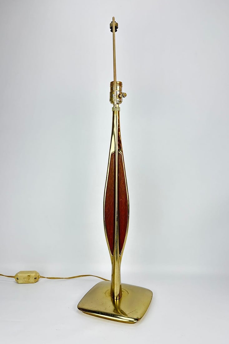 MID-CENTURY MODERN BRASS AND WALNUT TABLE LAMP: Mid-century modern sculptural table lamp with a polished brass "wishbone" or hourglass frame cradling a tapered walnut wood insert on a square brass base. Approximate Dimensions: 30”h x 