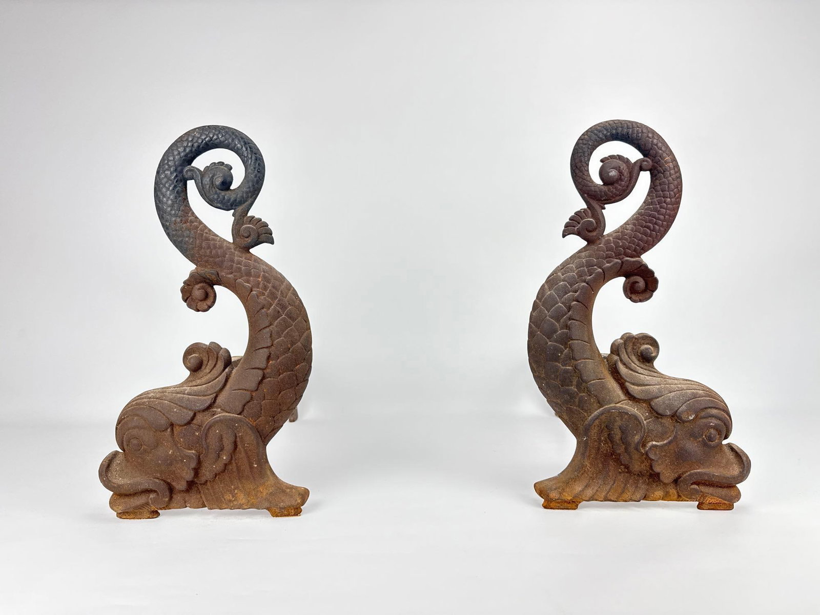 BRADLEY & HUBBARD DOLPHIN ANDIRONS: A pair of cast iron fireplace andirons in the shape of dolphins. Approximate Dimensions: 14”H x 8”W x 17”D Maker: Bradley & Hubbard Provenance: From a New York Collector Not