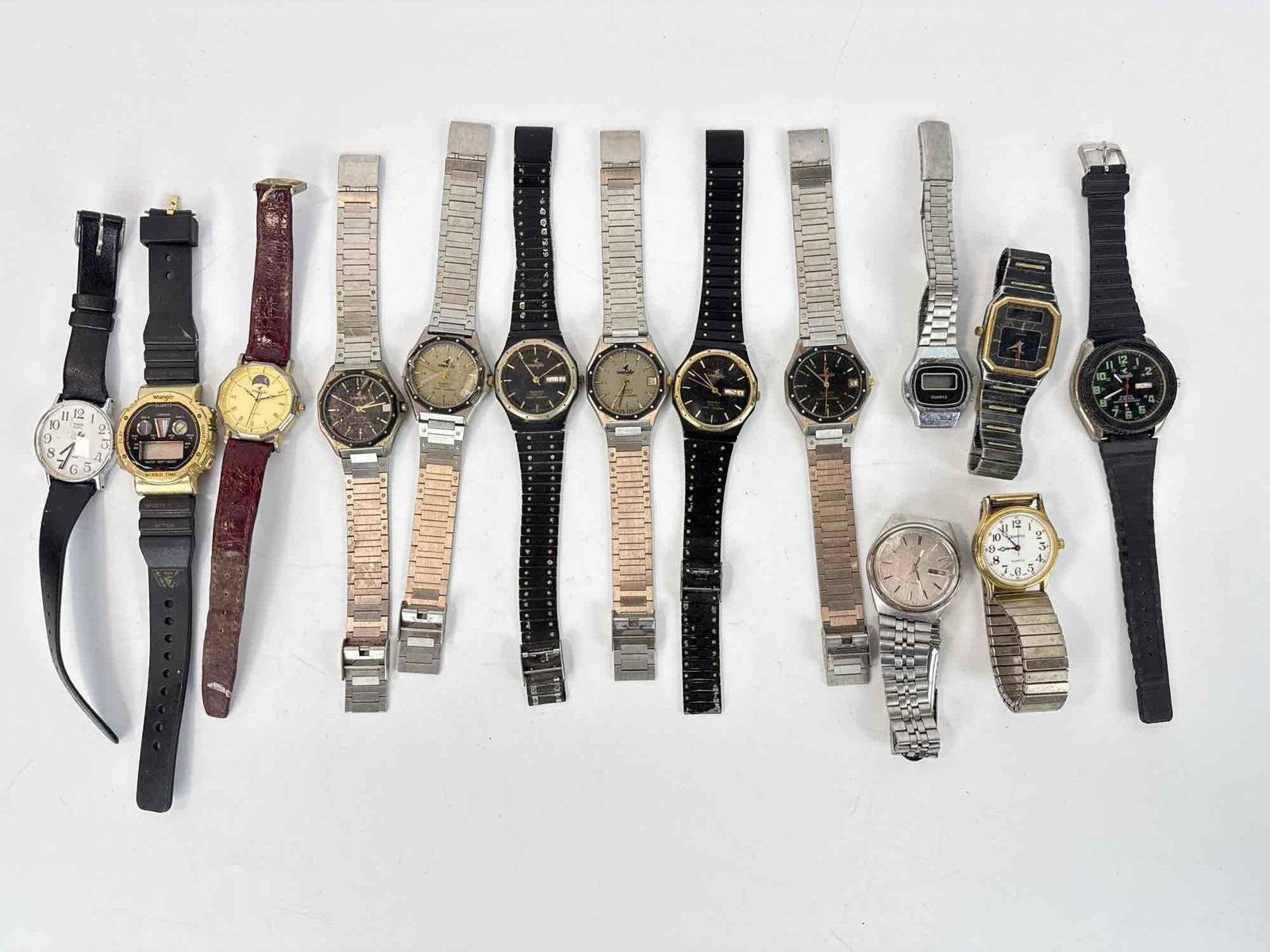ESTATE VINTAGE WATCH LOT INCLUDING WRANGLER, SEIKO, QUARTEX, AND TIMEX: An assortment of fourteen vintage and contemporary wristwatches consisting of analog and digital models with various metal, leather, and rubber straps. Has damage & not in working condition. Maker
