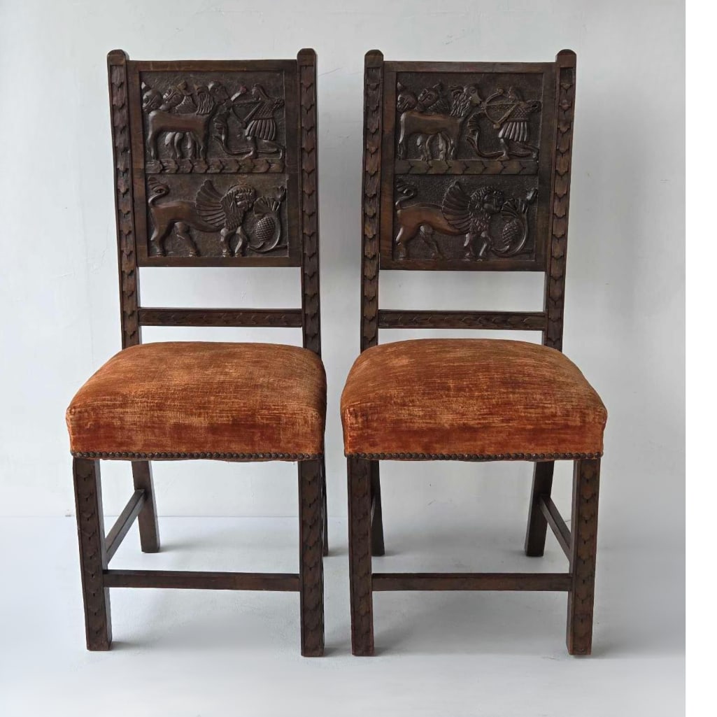 PAIR OF ITALIAN RENAISSANCE REVIVAL CARVED WALNUT SIDE CHAIRS: Set of two dark walnut chairs with high-relief carved back splats depicting winged lions and mythological scenes. Approximate Dimensions: 41.25"h x 18"w x 18.5"d Artist or Maker: Unknown P