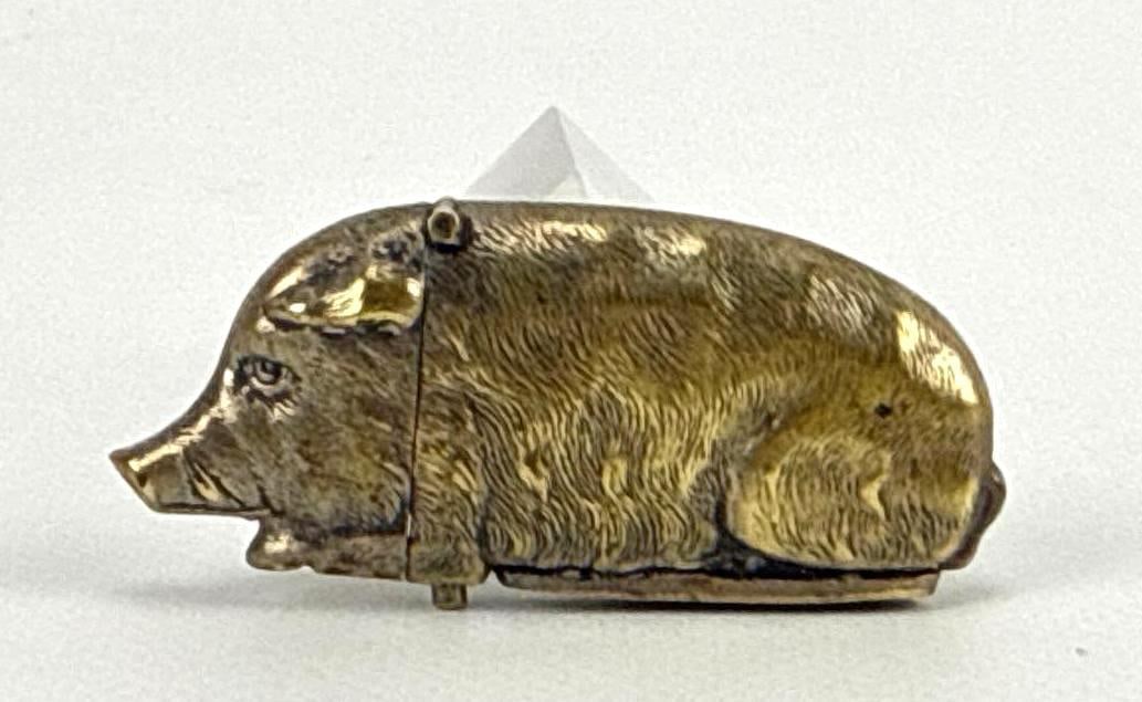 ANTIQUE BRASS PIG VESTA CASE MATCH SAFE & STRIKER: A brass novelty pig form match safe with hinged head and underside striker. Approximate Dimensions: 2” x 1” Maker: Unknown Provenance: From a Bridgehampton private collection