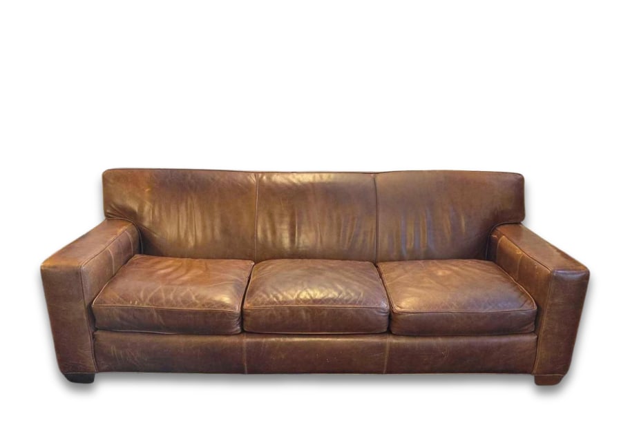 VINTAGE LEE INDUSTRIES BROWN LEATHER THREE-CUSHION SOFA: Three-seat track arm sofa upholstered in distressed cognac brown leather over low block feet. Approximate Dimensions: 32"h x 88"w x 39"d Artist or Maker: Lee Industries Pr