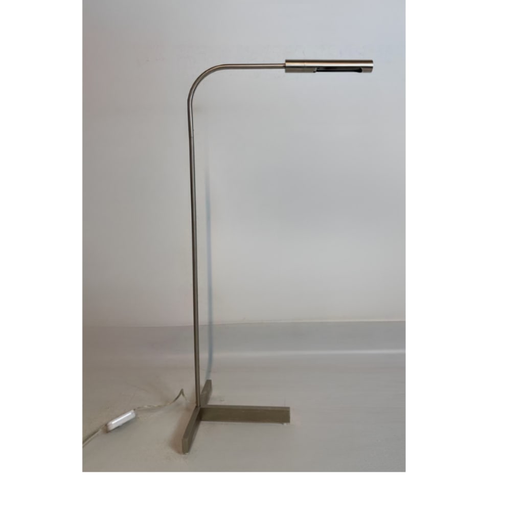 MID-CENTURY MODERNIST STAINLESS STEEL T-BASE PHARMACY FLOOR LAMP: A minimalist mid-century modern style stainless steel reading floor lamp constructed with a slender right-angle arching stem, an integrated cylinder shade with an under-mounted rocker switch, and a fl
