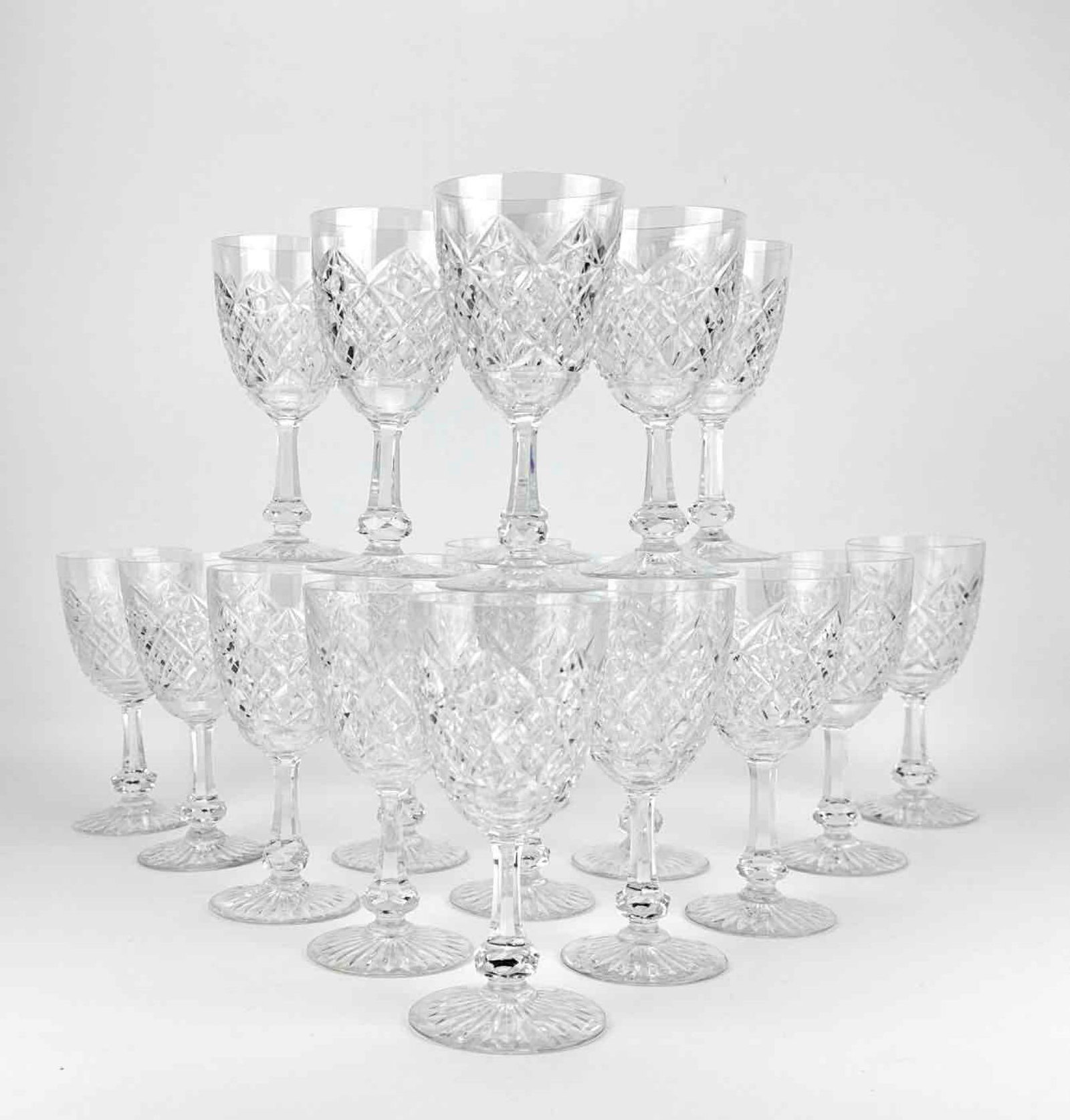 19 PIECE SET OF BACCARAT CRYSTAL CLARET WINE GLASSES IN COLBERT PATTERN: Antique French cut crystal claret wine stems with diamond criss-cross bowls, multi-sided stems with prominent faceted knops, and star-cut feet. Approximate Dimensions:Â 6â€h