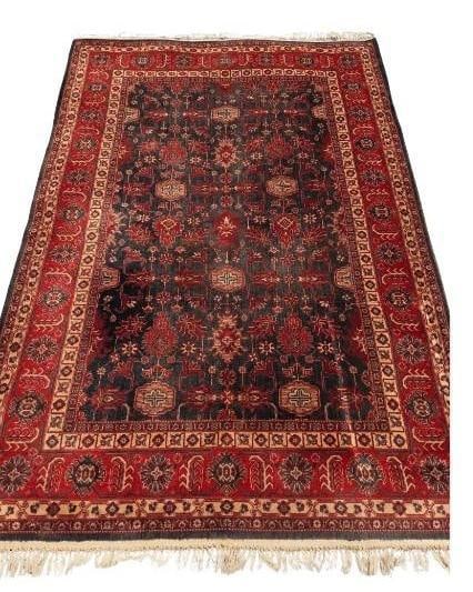 BOKHARA STYLE HAND-KNOTTED WOOL RUG: *A classic hand-knotted wool rug in the traditional Bokhara style, featuring a dense repeating pattern of "elephant foot" or gul motifs. Approximate Dimensions: 8' x 5'-6" Artist