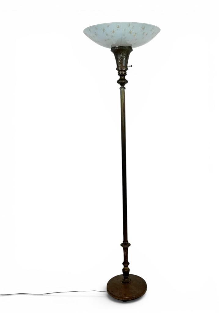 VINTAGE BRASS TORCHIERE FLOOR LAMP WITH ATOMIC STARBURST GLASS SHADE: An antique cast brass adjustable uplight standing floor lamp paired with a mid-century frosted glass saucer shade adorned with gold star pattern motifs. Approximate Dimensions: 66” x 18”