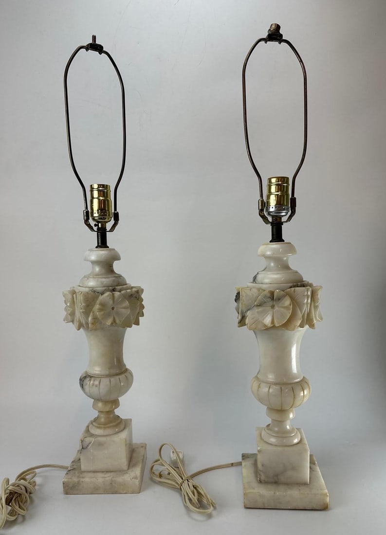 PAIR OF VINTAGE ITALIAN ALABASTER CARVED URN-FORM TABLE LAMPS: Pair of vintage neoclassical style carved white alabaster urn-form table lamps, featuring a central decorative band of relief-carved floral swags and a ribbed lower body, mounted on square plinth