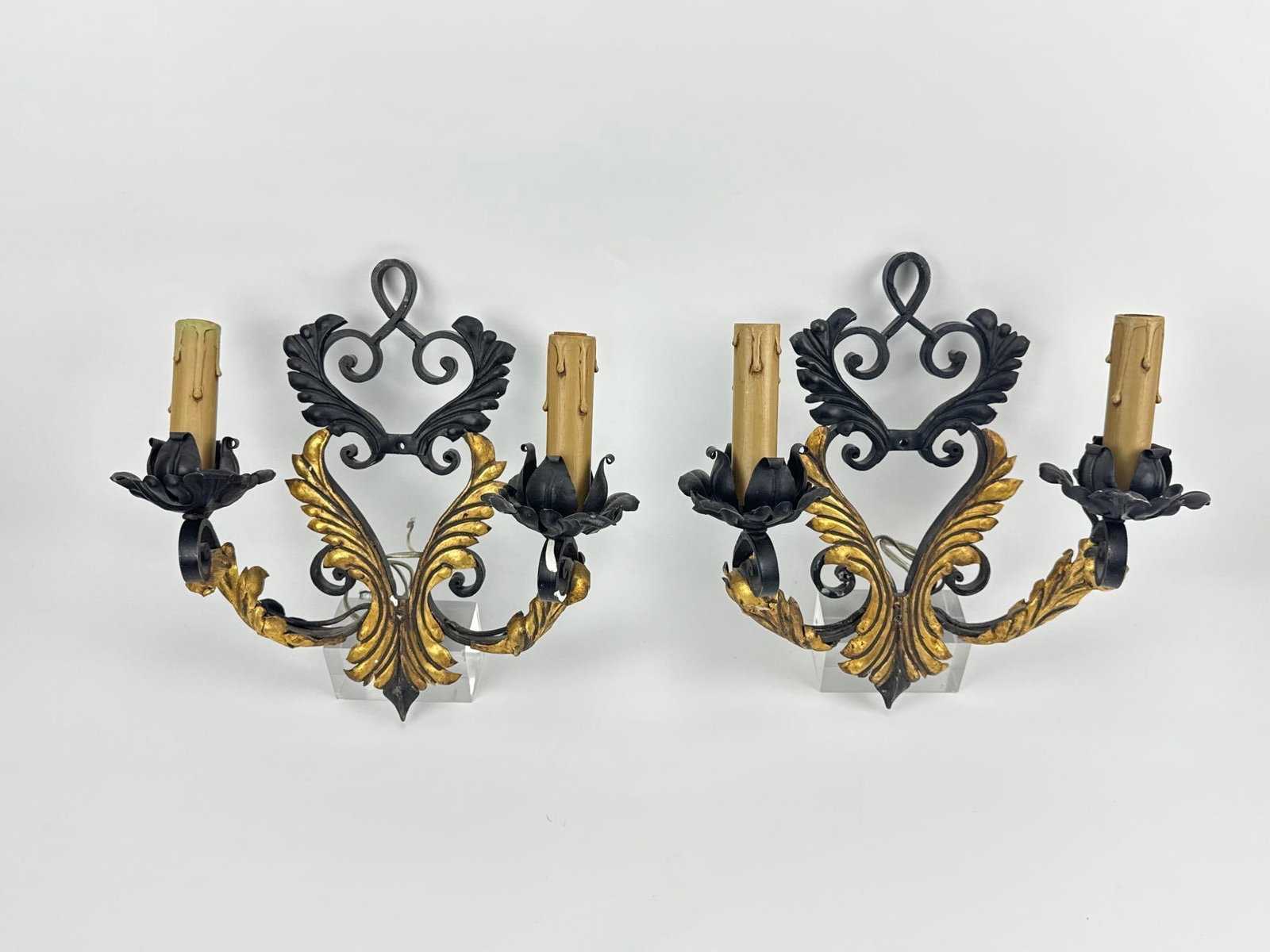 PAIR OF BAROQUE REVIVAL GILT AND PATINATED METAL SCONCES: *Two-light wall fixtures with scrolled acanthus leaf decoration and faux candle sleeves. Approximate Dimensions: 13.5”h x 12”w x 6”d Artist or Maker: Unknown Provenance: From a New