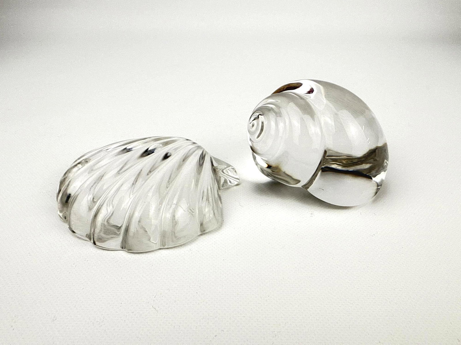 PAIR OF TIFFANY & CO. CRYSTAL SEASHELLS: Pair of vintage solid crystal table desk accessories in the form of seashells. Larger Approximate Dimensions: 2.5”H x 3”W x2.25”D Maker: Tiffany & Co. Provenance: From a New York