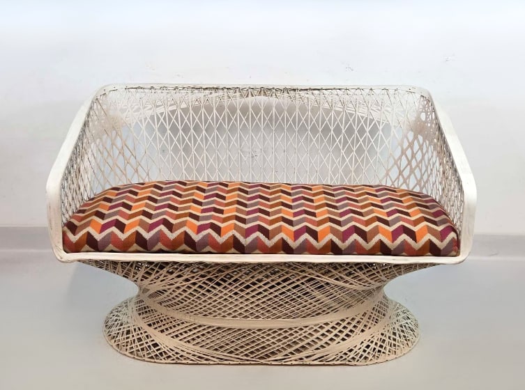 MID-CENTURY MODERN WOODARD SPUN FIBERGLASS SETTEE: A Mid-Century Modern "Inca" style spun fiberglass two-seat settee by Woodard. Features a white woven-lattice frame paired with a removable chevron-patterned fabric seat cushion. Approximate Di