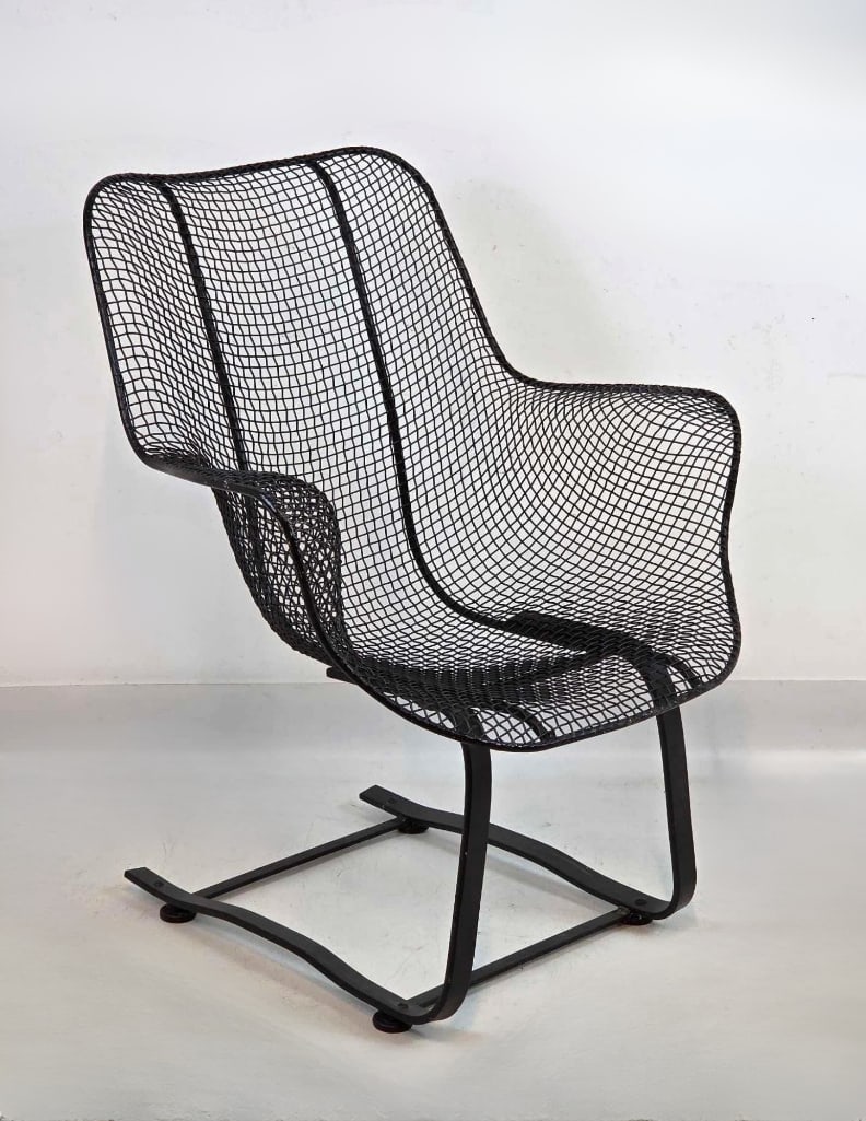 RUSSELL WOODARD SCULPTURA CHAIR: A black, iron wire mesh lounge chair on a continuous cantilevered sled base providing bounce. Approximate Dimensions: 34.5"H x 27"W x 26"D Artist or Maker: Russell Woodard Provenance: From