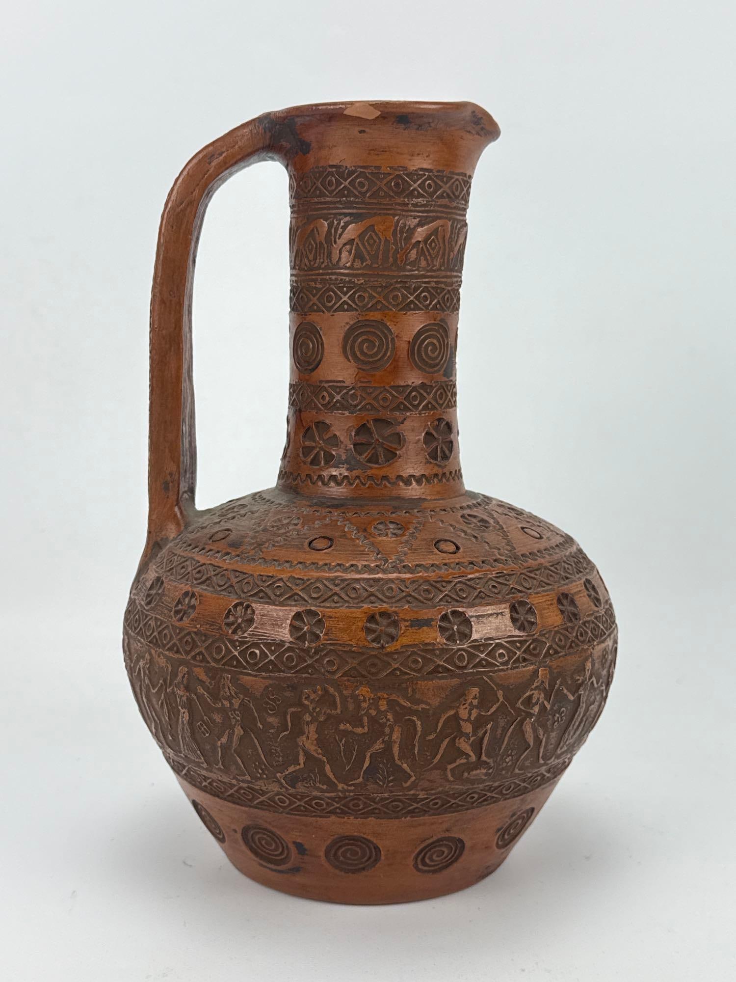 VINTAGE GREEK GEOMETRIC REPRODUCTION OLPE POTTERY VASE: Vintage terracotta single-handled pitcher or olpe, hand-carved with a classical Greek Geometric period revival design featuring rows of rosettes, spirals, and a low-relief frieze of stylized human fig