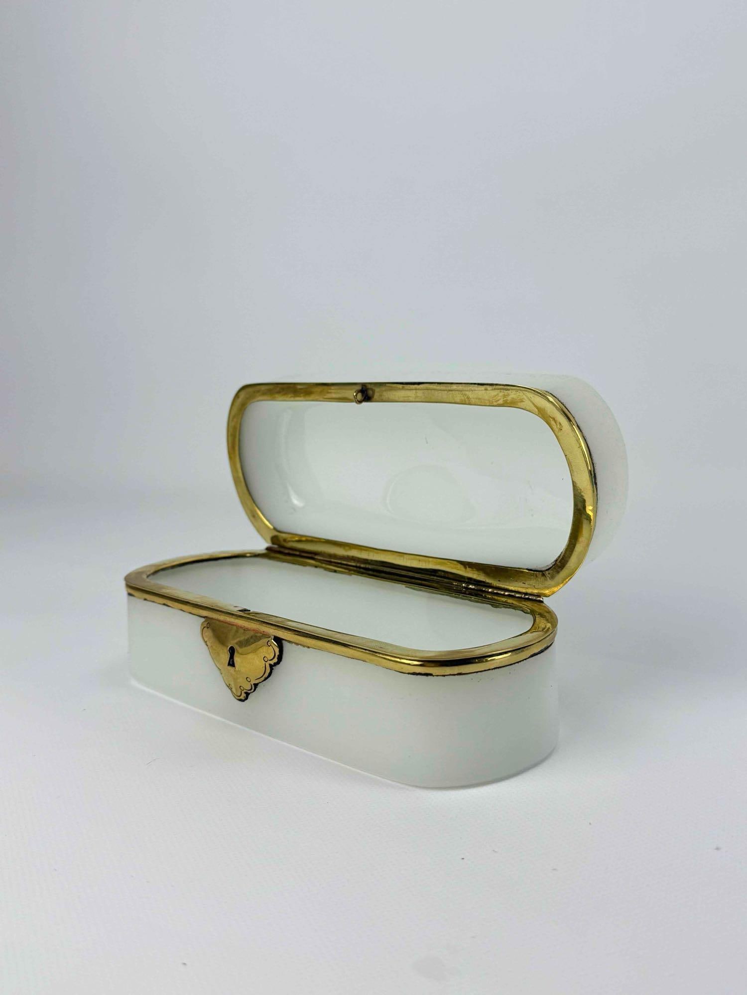 FRENCH WHITE OPALINE GLASS CASKET BOX WITH BRASS MOUNTS: 19th-century French milk-white opaline glass rectangular vanity casket box with a hinged lid and decorative gilded brass escutcheon plate. Approximate Dimensions: 7”x3”x3” Artist or 