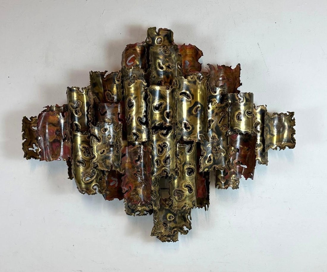 MID-CENTURY MODERN SIGNED SILAS BRUTALIST TORCH-CUT BRASS AND COPPER WALL SCULPTURE - JERÉ STYLE: Mid-20th-century abstract Brutalist wall hanging sculpture composed of multi-layered, interlocking torch-cut brass and copper cylinders with jagged, organic aperture and fire-scaled patination. Approx