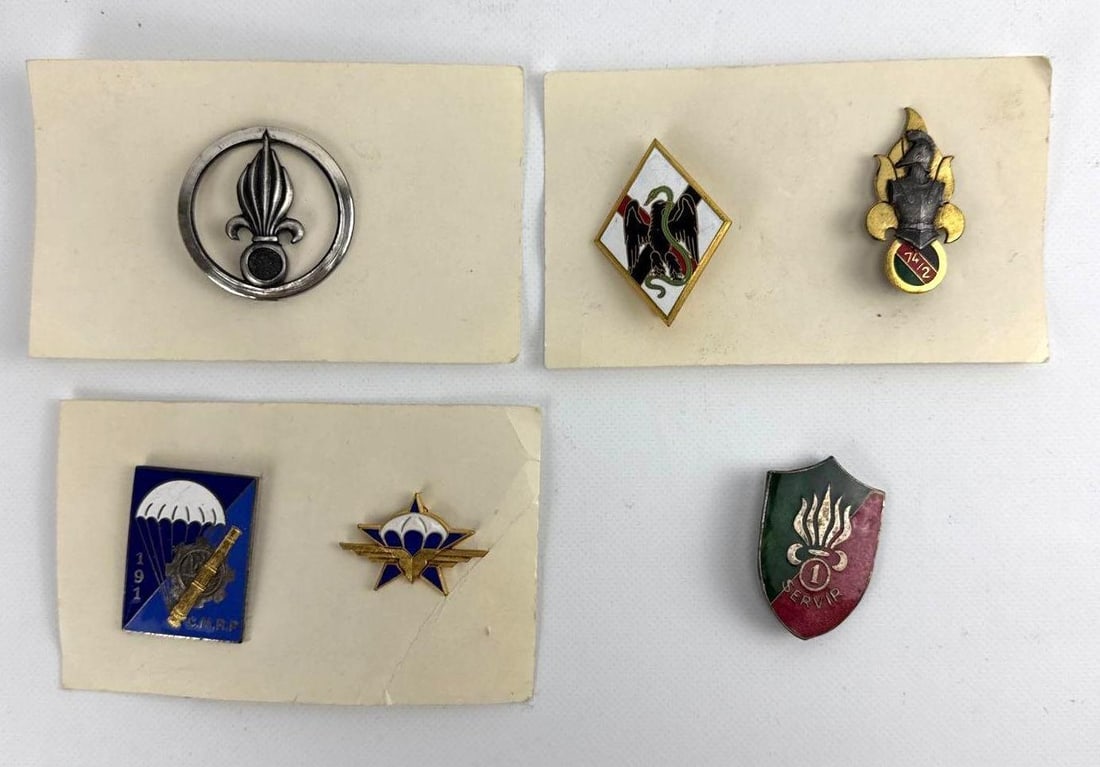 VALUE LOT: ASSORTMENT OF FRENCH FOREIGN LEGION INSIGNIA PINS: A collection of six colorful enameled and metal military regimental badges including paratrooper wings and flaming grenade motifs. Largest Approximate Dimensions: 1.75” Dia Artist or Maker: Vari