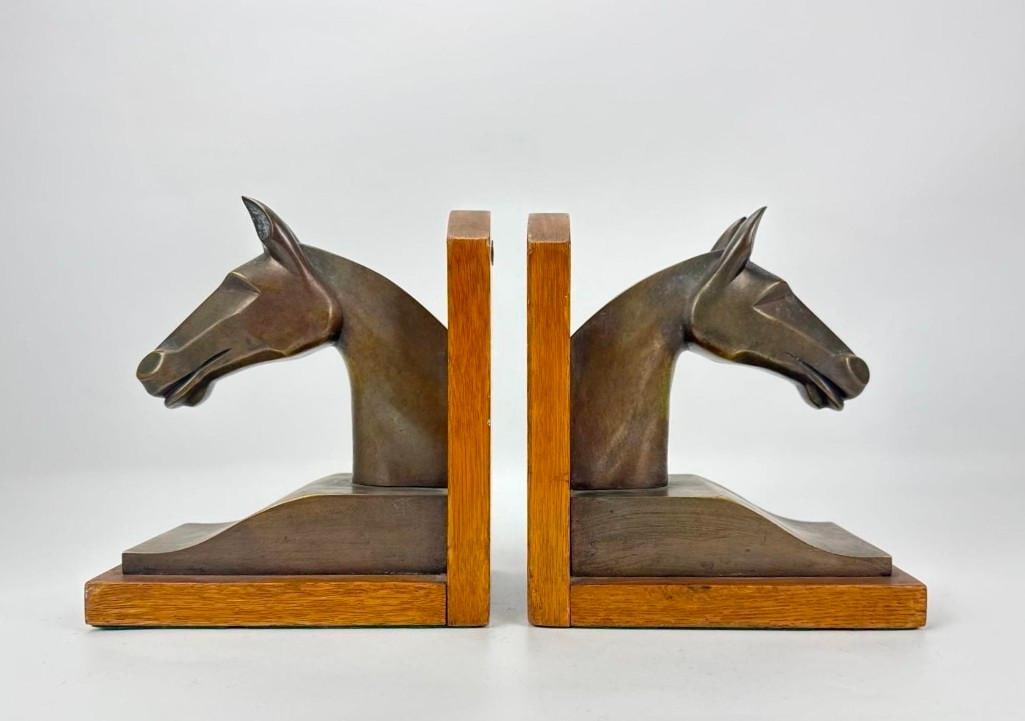 SIGNED HERMÈS PARIS FRENCH ART DECO PATINATED BRONZE AND OAK EQUESTRIAN HORSE HEAD BOOKENDS: Pair of French Art Deco patinated bronze stylized modernist horse head bookends mounted on arched oak bases. Originally presented as trophy or award. Approximate Dimensions: 7.75” h x 4.5”