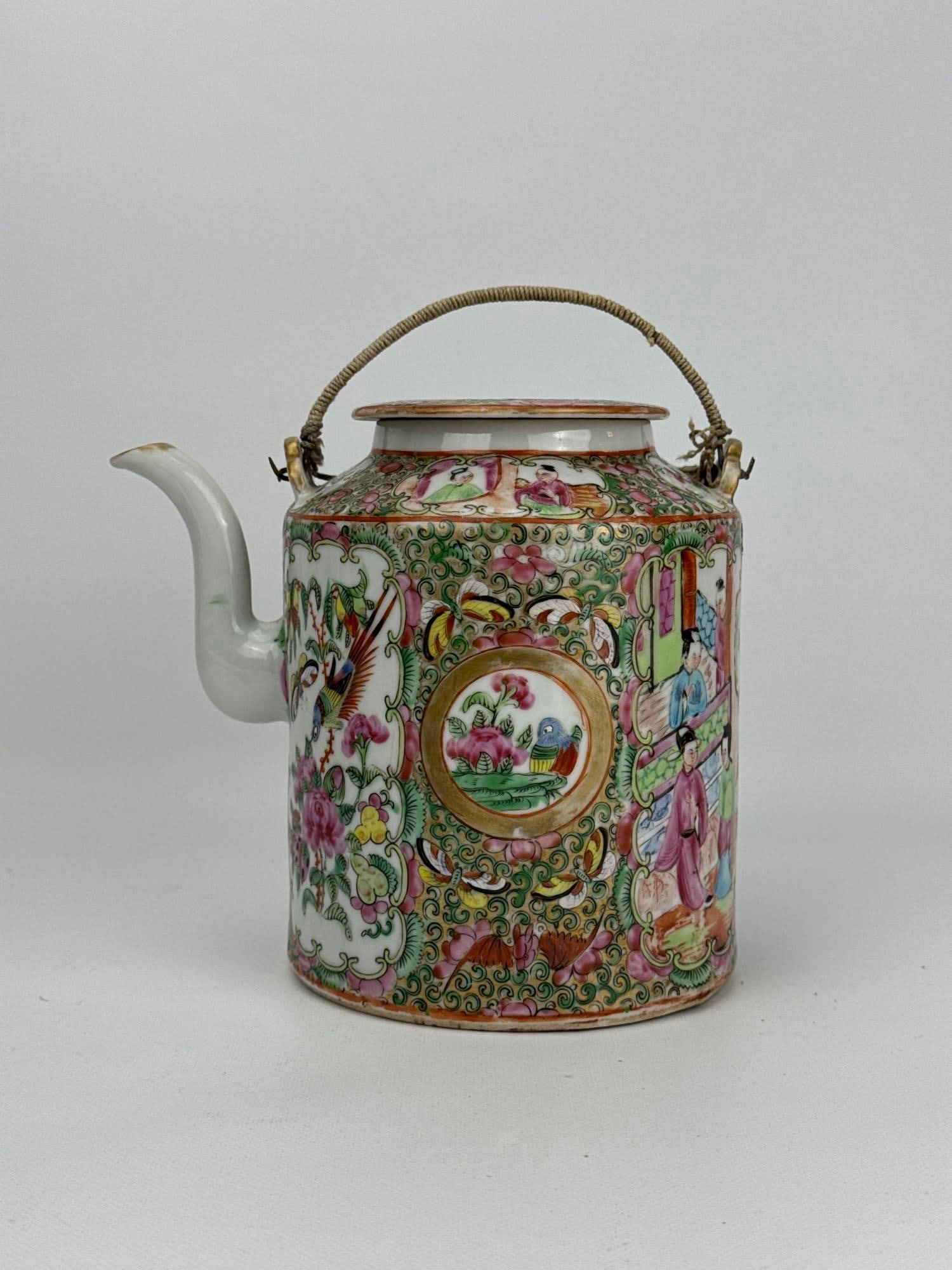 ANTIQUE FAMILLE ROSE MEDALLION PORCELAIN TEAPOT: A 19th-century Chinese export porcelain cylindrical teapot with a flat inset lid and a wrapped wire bail handle, densely decorated in the traditional Rose Medallion pattern with alternating panels of 