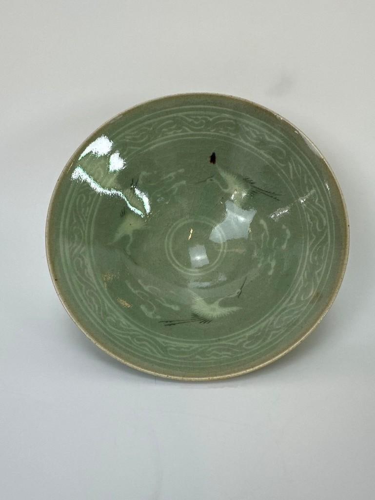 KOREAN STYLE CELADON GLAZED BOWL WITH INLAID CRANE DESIGN – UNDERGLAZE BLUE MARK TO BASE: Small Celadon glazed bowl with inlaid crane motifs and unidentified underglaze blue marks. Dimensions: 6”diameter x 2.25” tall Artist or Maker: Unknown Provenance: From the personal collec