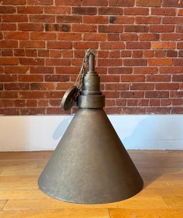 LARGE POSTMODERN VINTAGE INDUSTRIAL FACTORY PENDANT LIGHT – BRASS CONE FORM WAREHOUSE LAMP: Oversized brass conical factory pendant light with chain suspension. Pick up Note: This lot is located in Manhattan NYC, and must picked up in Manhattan. Estimated Approximate Dimensions: 18" x 16