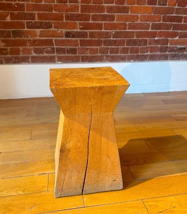 CHRISTIAN LIAIGRE NAGATO STOOL IN NATURAL WOOD FINISH: A Christian Liaigre Nagato stool, crafted from wood with a natural finish, featuring a distinctive geometric shape. From the Moschino NYC showroom. Pick up Note: This lot is located in Manhattan NYC, 